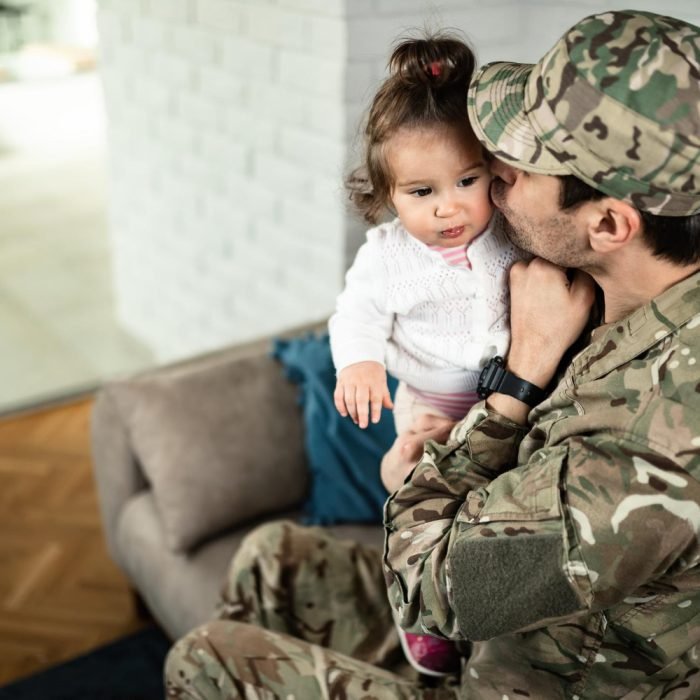 loving-soldier-kissing-his-small-daughter-while-spending-time-with-her-home